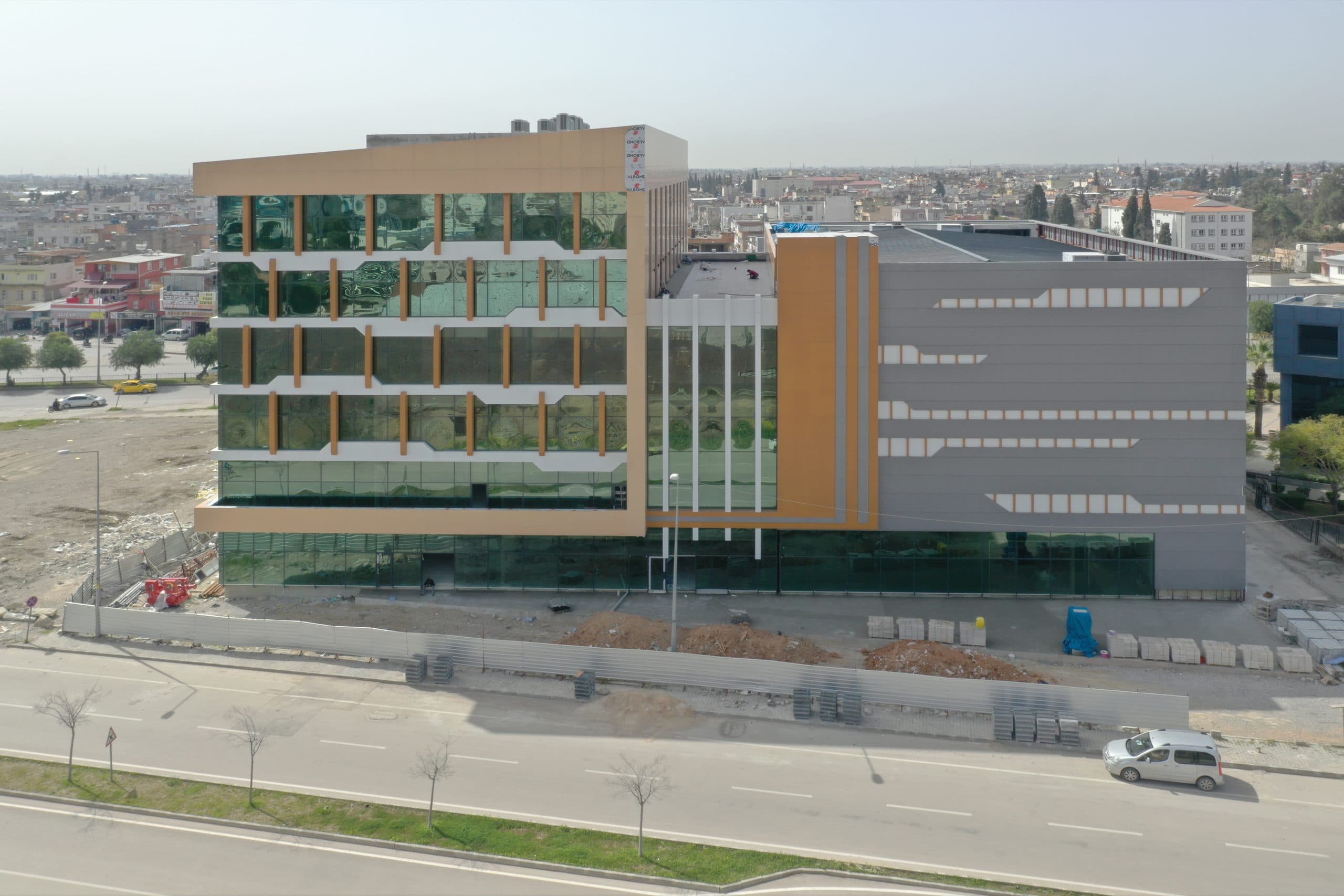 ATO binasının cadde cephesi havadan: cam blok, bakır renkli kompozit kule ve gri ek blok