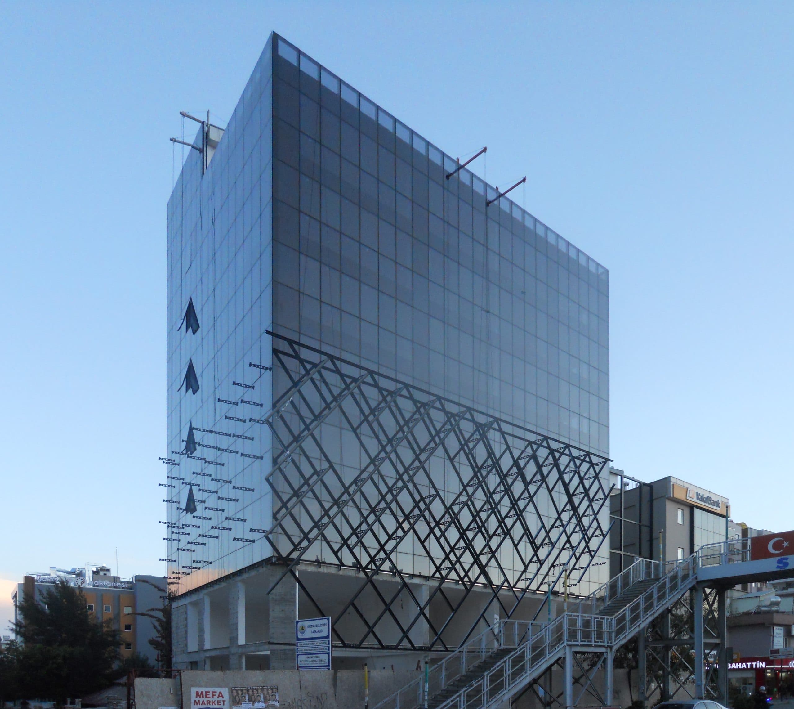 Kayıkçıoğlu Next Office yapım aşamasında: cam cephe ve elmas desenli kafes montajı, akşam ışığı