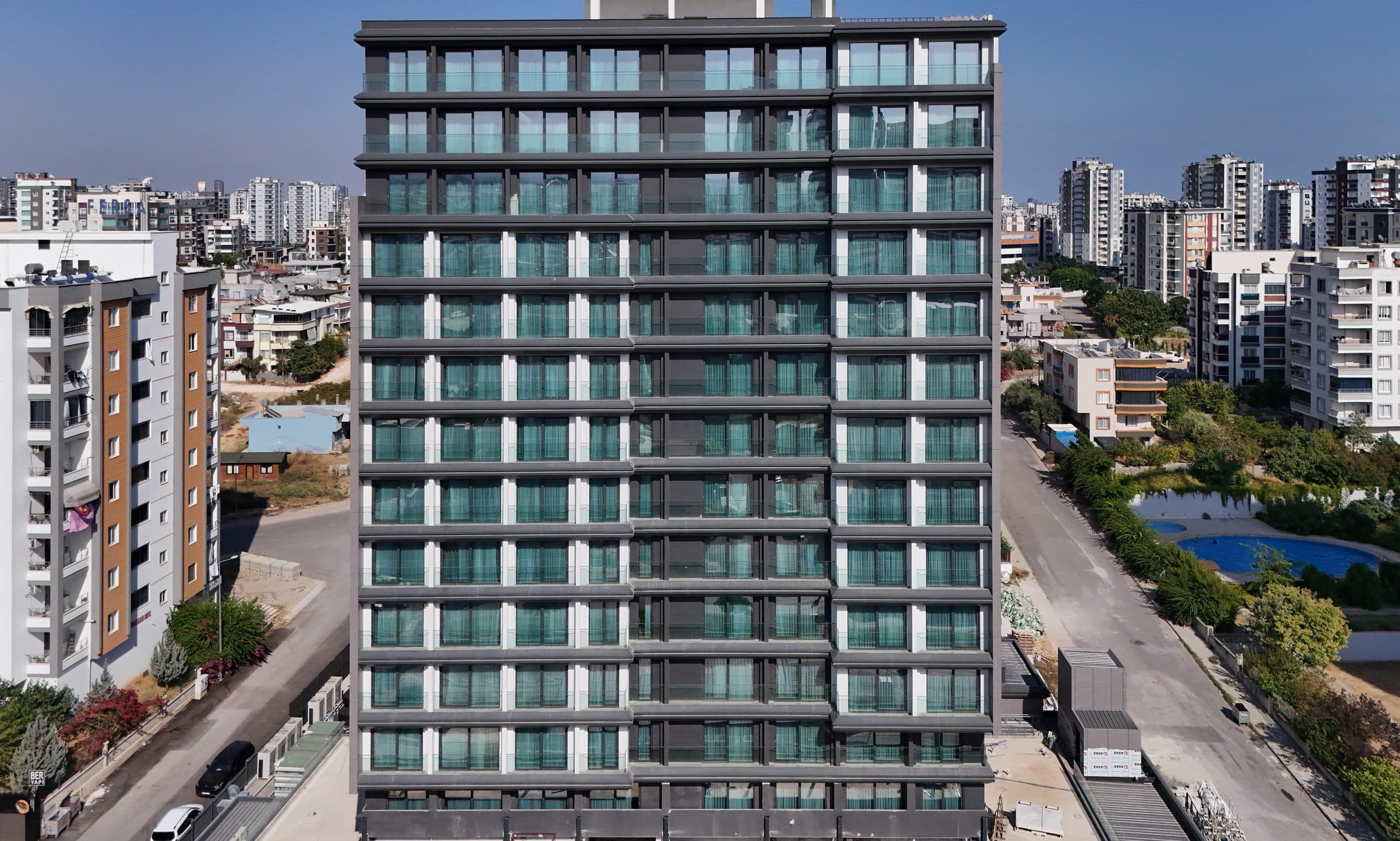Ramada Plaza otel kulesinin cepheden simetrik görünümü, kat kat cam korkuluklu balkon ritmi