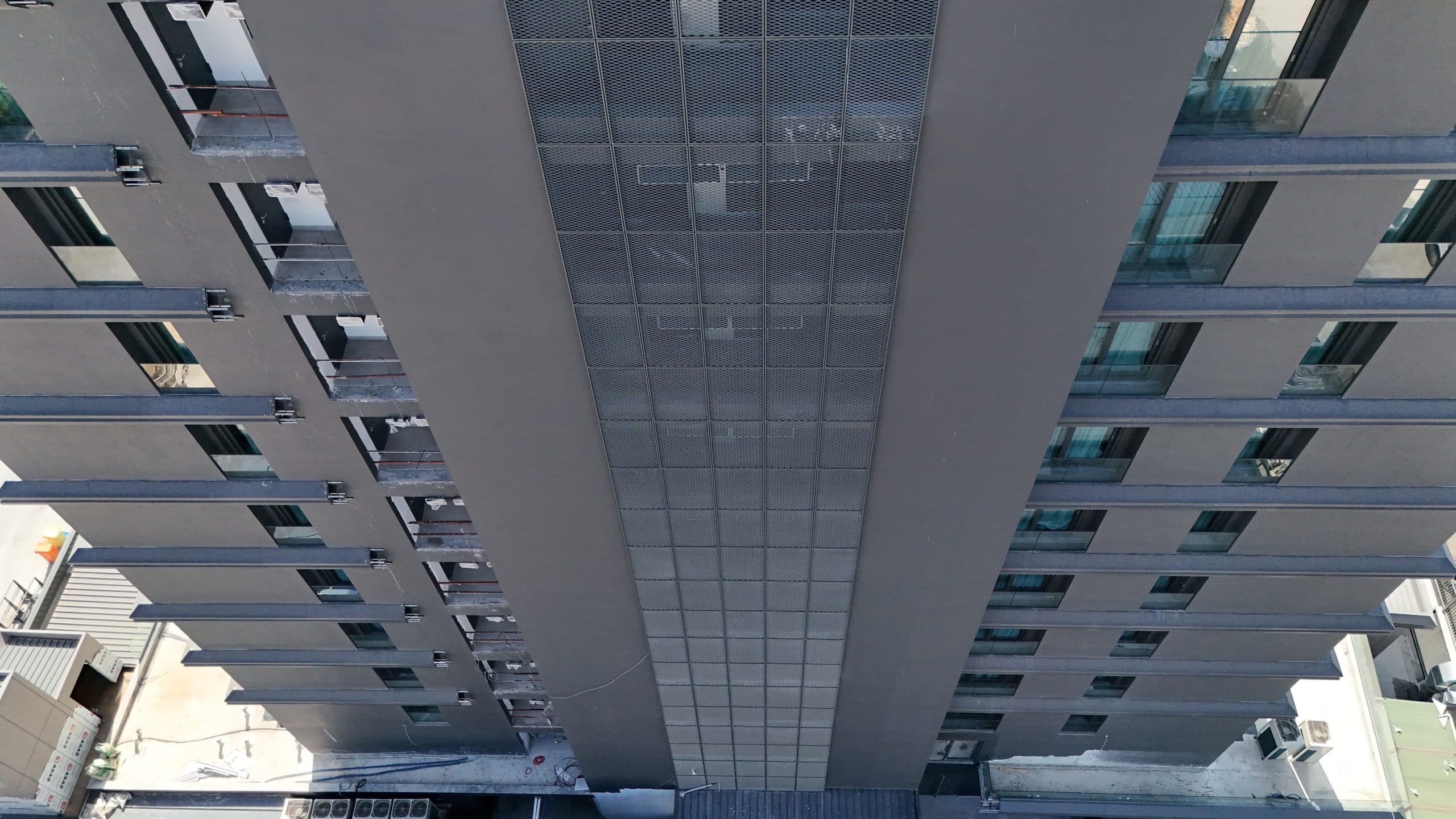 Otel kulesinin çekirdeğindeki mesh dolgulu cam şeridin yukarıdan derin perspektif görünümü